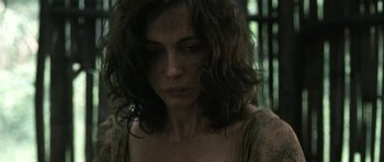 Movie still from “Vinyan” (2008), directed by Fabrice du Welz – A person with long curly hair; Close Up shot, Low angle