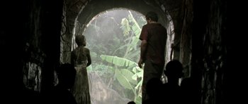 Movie still from “Vinyan” (2008), directed by Fabrice du Welz – A man and a woman standing in front of an opening in a tunnel; Wide shot, Low angle