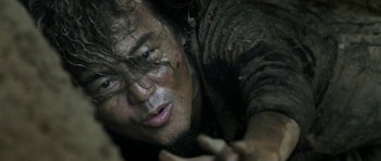 Movie still from “Vinyan” (2008), directed by Fabrice du Welz – A man with a beard is laying on the ground; Close Up shot, Low angle