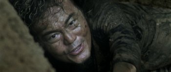 Movie still from “Vinyan” (2008), directed by Fabrice du Welz – A man's face in the mud; Close Up shot, Low angle