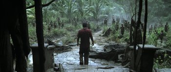 Movie still from “Vinyan” (2008), directed by Fabrice du Welz – A group of people standing in the jungle; Extreme Wide shot, High angle
