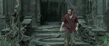 Movie still from “Vinyan” (2008), directed by Fabrice du Welz – A man walking down a set of stairs; Wide shot, Low angle