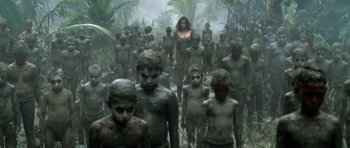 Movie still from “Vinyan” (2008), directed by Fabrice du Welz – A group of people standing in the jungle; Wide shot, High angle