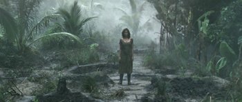 Movie still from “Vinyan” (2008), directed by Fabrice du Welz – A woman standing in the middle of a forest; Wide shot, High angle