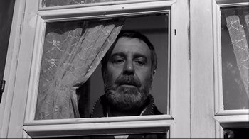 Movie still from “Viridiana” (1961), directed by Luis Buñuel – A man with a beard looking out of a window; Close Up shot, Low angle