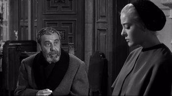 Movie still from “Viridiana” (1961), directed by Luis Buñuel – An older man and a young woman in a room; Medium shot, Over the shoulder angle