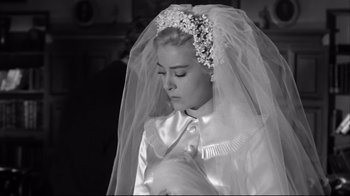 Movie still from “Viridiana” (1961), directed by Luis Buñuel – A woman wearing a wedding dress and a veil; Close Up shot, Over the shoulder angle