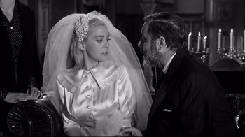 Movie still from “Viridiana” (1961), directed by Luis Buñuel – An older man and a young woman in wedding attire; Medium shot, Over the shoulder angle