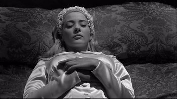 Movie still from “Viridiana” (1961), directed by Luis Buñuel – A woman in a white dress and a flower in her hair; Close Up shot, High angle