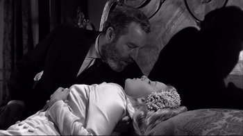 Movie still from “Viridiana” (1961), directed by Luis Buñuel – A black and white photo of a man kissing a woman; Close Up shot, High angle