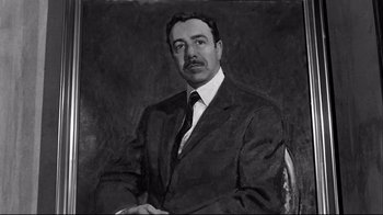 Movie still from “Viridiana” (1961), directed by Luis Buñuel – A black - and - white photo of a man in a suit and tie; Medium shot, Low angle