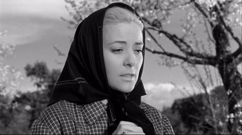 Movie still from “Viridiana” (1961), directed by Luis Buñuel – A young woman wearing a black scarf and a plaid jacket; Close Up shot, Low angle