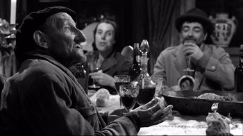 Movie still from “Viridiana” (1961), directed by Luis Buñuel – A group of people sitting at a table drinking wine; Medium shot, Low angle