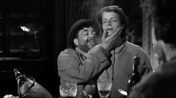 Movie still from “Viridiana” (1961), directed by Luis Buñuel – An old photo of a man and a woman smoking; Medium shot, Low angle