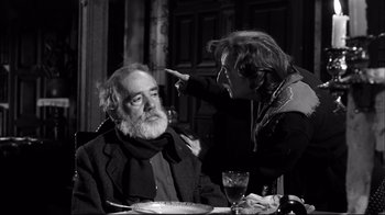 Movie still from “Viridiana” (1961), directed by Luis Buñuel – An older man sitting at a table with a woman; Medium shot, Over the shoulder angle