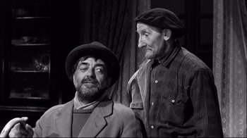 Movie still from “Viridiana” (1961), directed by Luis Buñuel – Two men are standing next to each other; Medium shot, Low angle