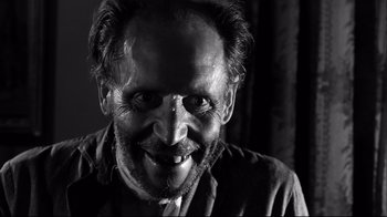 Movie still from “Viridiana” (1961), directed by Luis Buñuel – A black and white photo of a man smiling; Close Up shot, Low angle