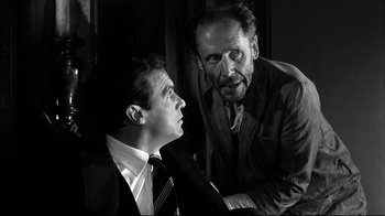 Movie still from “Viridiana” (1961), directed by Luis Buñuel – A man and a man in a suit and tie talking to each other; Close Up shot, Low angle
