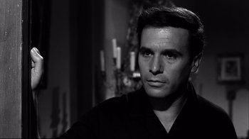 Movie still from “Viridiana” (1961), directed by Luis Buñuel – Black and white photograph of a man in front of candles; Close Up shot, Over the shoulder angle