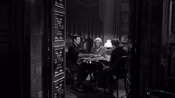 Movie still from “Viridiana” (1961), directed by Luis Buñuel – A group of people sitting around a table; Wide shot, High angle