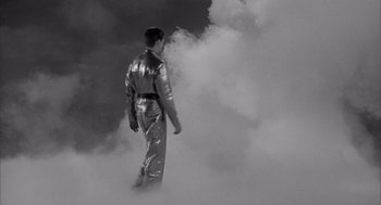 Movie still from “Visit to a Small Planet” (1960), directed by Norman Taurog – A man in a silver suit walking through smoke; Wide shot, Low angle