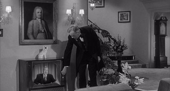 Movie still from “Visit to a Small Planet” (1960), directed by Norman Taurog – A black and white photo of a man in a suit and tie; Medium shot, High angle