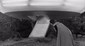 Movie still from “Visit to a Small Planet” (1960), directed by Norman Taurog – A man standing in front of a slide in a field; Extreme Wide shot, High angle