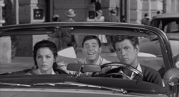 Movie still from “Visit to a Small Planet” (1960), directed by Norman Taurog – A group of men and women in the back of a car; Medium shot, Over the shoulder angle