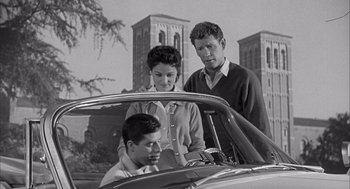 Movie still from “Visit to a Small Planet” (1960), directed by Norman Taurog – A man and a woman and a young boy standing in the back seat of a car; Medium shot, Low angle