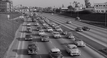 Movie still from “Visit to a Small Planet” (1960), directed by Norman Taurog – A black - and - white photo of a freeway filled with traffic; Extreme Wide shot, High angle