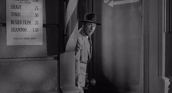 Movie still from “Visit to a Small Planet” (1960), directed by Norman Taurog – A black and white photo of a man in a suit and hat; Medium shot, High angle