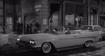 Movie still from “Visit to a Small Planet” (1960), directed by Norman Taurog – An old photo of people sitting in the back of a car; Wide shot, High angle