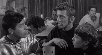 Movie still from “Visit to a Small Planet” (1960), directed by Norman Taurog – A group of young men sitting around a table; Medium shot, Over the shoulder angle