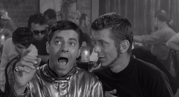 Movie still from “Visit to a Small Planet” (1960), directed by Norman Taurog – Two young men pose for a picture in front of a crowd; Close Up shot, Over the shoulder angle