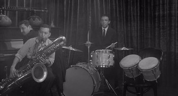 Movie still from “Visit to a Small Planet” (1960), directed by Norman Taurog – Two men in suits are playing drums and a saxophone; Medium shot, High angle