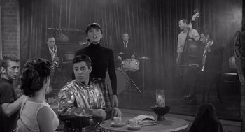 Movie still from “Visit to a Small Planet” (1960), directed by Norman Taurog – A group of people sitting around a table; Medium shot, Over the shoulder angle