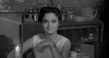 Movie still from “Visit to a Small Planet” (1960), directed by Norman Taurog – A black - and - white photo of a woman sitting at a table; Close Up shot, Over the shoulder angle