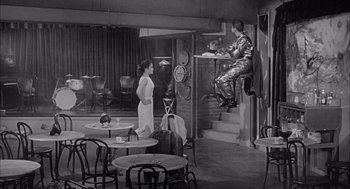 Movie still from “Visit to a Small Planet” (1960), directed by Norman Taurog – An old photo of a man sitting on the stairs; Wide shot, High angle