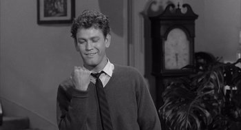 Movie still from “Visit to a Small Planet” (1960), directed by Norman Taurog – A man in a sweater and a neck tie; Medium shot, Over the shoulder angle