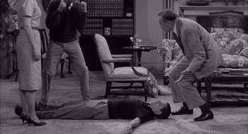 Movie still from “Visit to a Small Planet” (1960), directed by Norman Taurog – A man laying on the ground in front of two other men; Wide shot, High angle