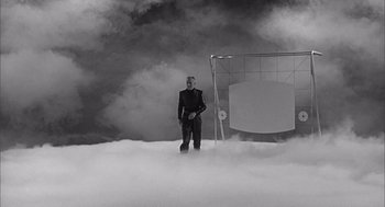 Movie still from “Visit to a Small Planet” (1960), directed by Norman Taurog – A man standing in the middle of a cloud filled sky; Wide shot, Low angle