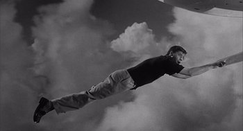 Movie still from “Visit to a Small Planet” (1960), directed by Norman Taurog – A man flying through the air while holding onto a parachute; Medium shot, Low angle
