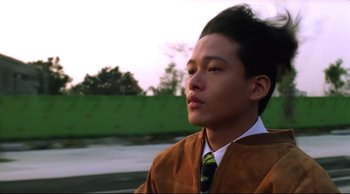 Movie still from “Vive L'Amour” (1994), directed by Tsai Ming-liang – A man in a brown jacket and a green neck tie; Close Up shot, Low angle