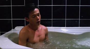 Movie still from “Vive L'Amour” (1994), directed by Tsai Ming-liang – A man sitting in a bathtub with his eyes closed; Medium shot, High angle