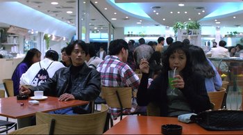 Movie still from “Vive L'Amour” (1994), directed by Tsai Ming-liang – A group of people sitting at tables in a room; Medium shot, High angle