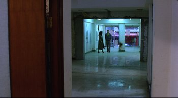 Movie still from “Vive L'Amour” (1994), directed by Tsai Ming-liang – Two people are walking in an empty building; Wide shot, High angle