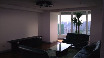 Movie still from “Vive L'Amour” (1994), directed by Tsai Ming-liang – A living room filled with furniture next to a large window; Wide shot, High angle
