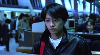 Movie still from “Vive L'Amour” (1994), directed by Tsai Ming-liang – A man in a leather jacket looking at a computer screen; Close Up shot, High angle
