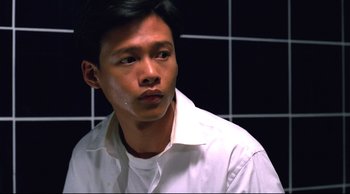 Movie still from “Vive L'Amour” (1994), directed by Tsai Ming-liang – A man in a white shirt is looking at the camera; Close Up shot, Low angle