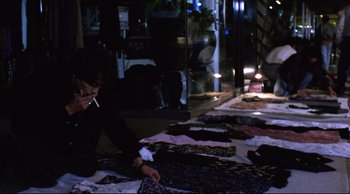 Movie still from “Vive L'Amour” (1994), directed by Tsai Ming-liang – A man sitting on the floor in front of a bunch of clothes; Medium shot, High angle